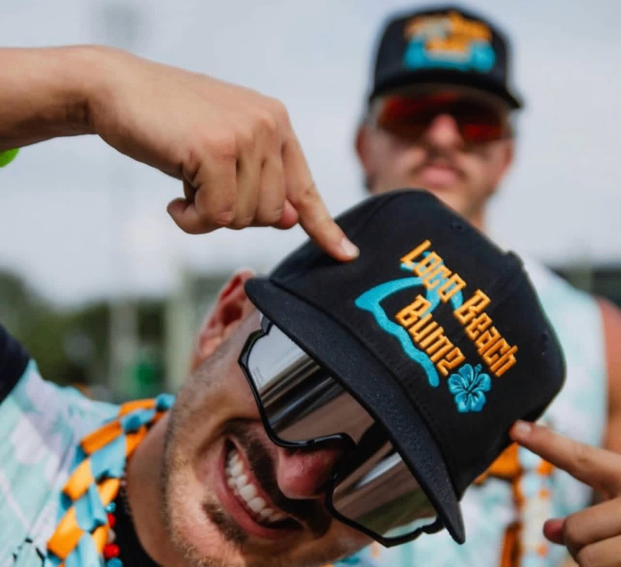 Smiling player tipping a Loco Beach Bumz cap